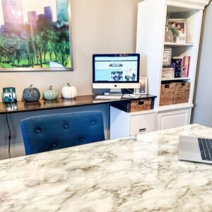 Angela Ramsey’s home office workspace with a marble desk, teal chair, computer, and white bookshelves, representing her creative space for the Everyday Living, Beautifully Made lifestyle blog.