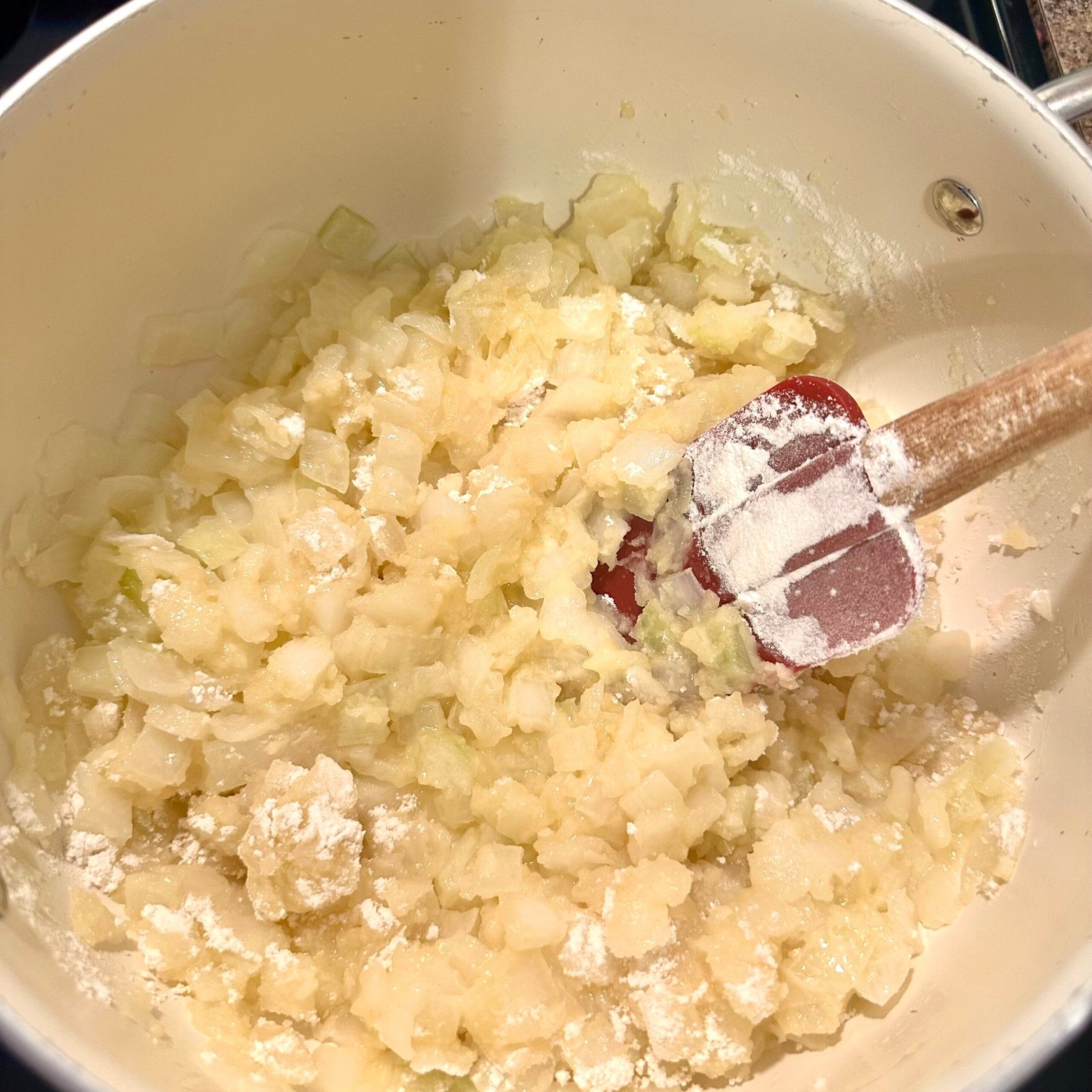 Onions and flour cooking together in a pot to create the base for homemade broccoli cheddar soup.