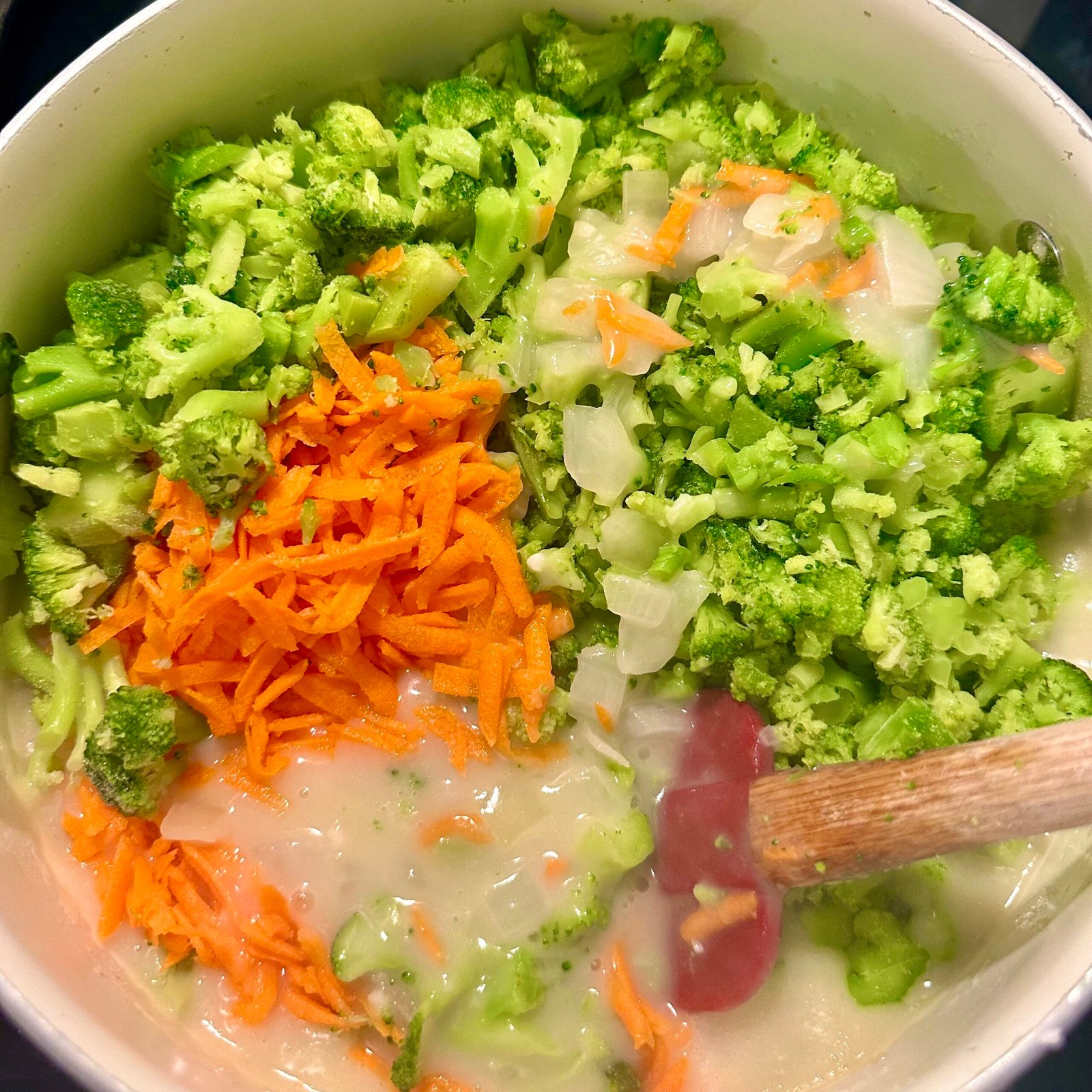 Chopped broccoli and shredded carrots added to the pot to make creamy homemade broccoli cheddar soup.